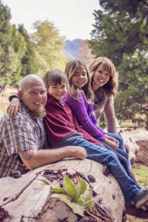 family sitting on fallen tree