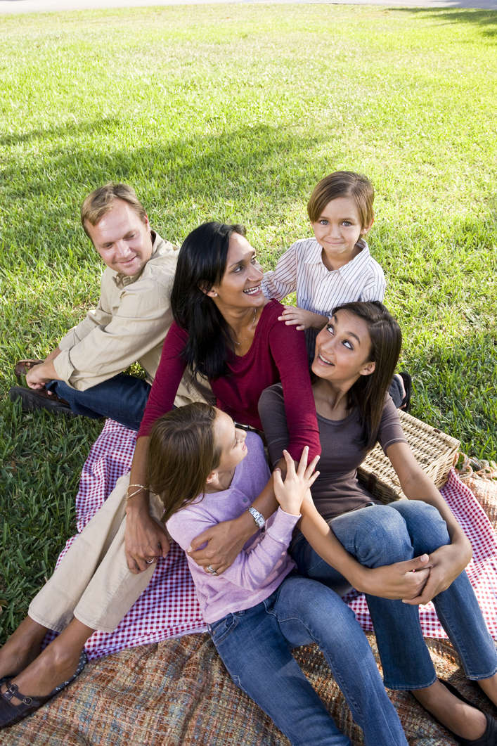 Family of five having picnic in park