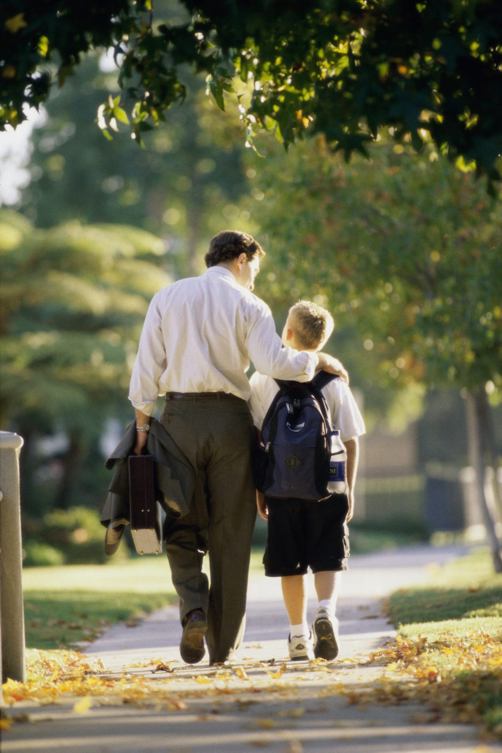 Rear view of a father walking with his son